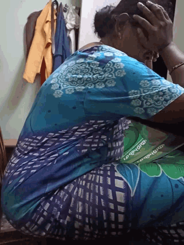 a woman in a blue and green dress has the word ' malayalam ' on her back