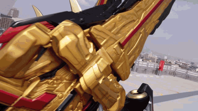 a gold and red toy with a red stripe on the side