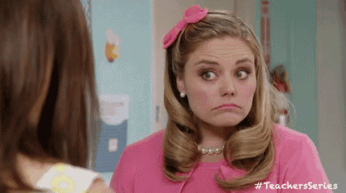 a woman in a pink dress with a pink bow in her hair is making a sad face .