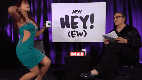 a woman in a blue dress is dancing in front of a sign that says hey