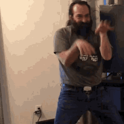 a man with a beard wears a shirt that says wolf pack