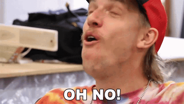 a man wearing a tie dye shirt and a red hat is saying oh no