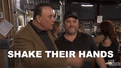 two men shake their hands in front of a sign that says happy hour