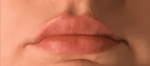 a close up of a woman 's lips with pink lipstick on .