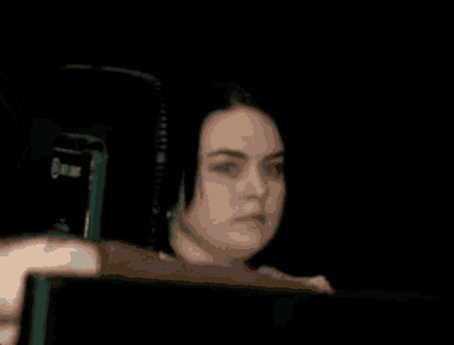 a woman with black hair is sitting in a chair in front of a computer monitor .