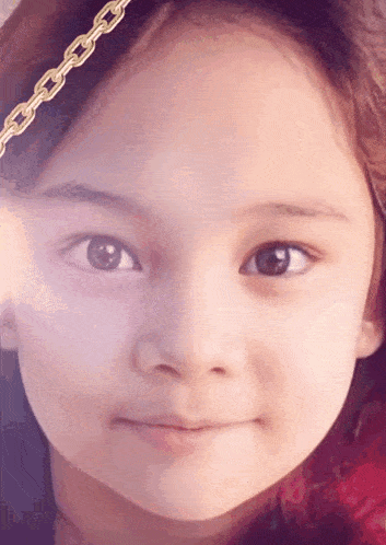 a little girl with a gold chain around her head looks at the camera
