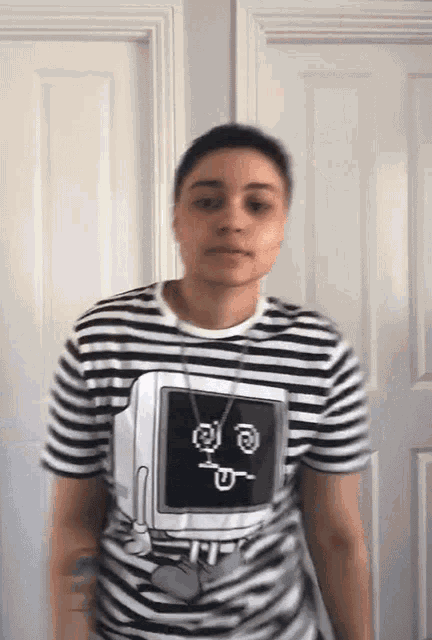 a woman wearing a black and white striped shirt with a computer monitor on it .