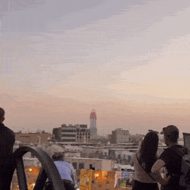 a group of people looking at a city skyline with a sign that says honey