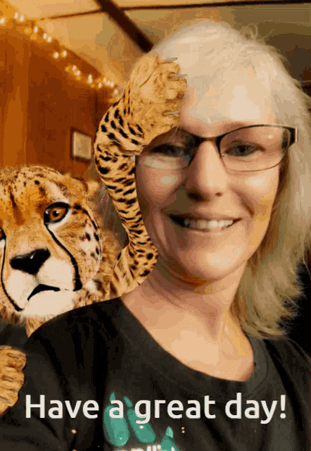 a woman with glasses holds a stuffed cheetah in front of her face