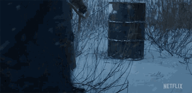 a netflix ad shows a person standing in the snow near a barrel