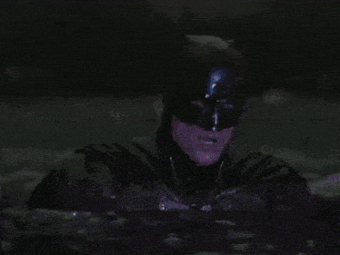 a close up of a man in a batman costume in the water