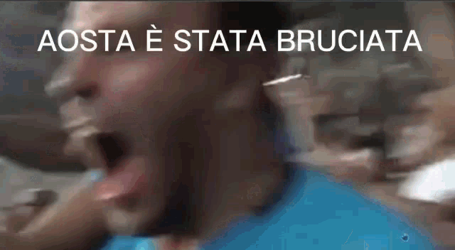 a blurry picture of a man with his mouth open and the words aosta e stata bruciata above him