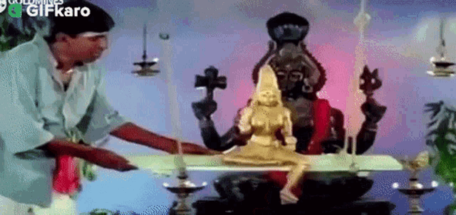 a man is standing next to a statue of a woman in a temple .