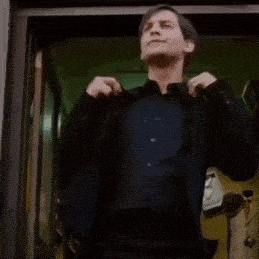 a man in a suit is dancing in a doorway while a woman watches .