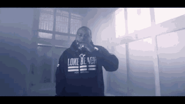 a man wearing a hoodie that says lone black