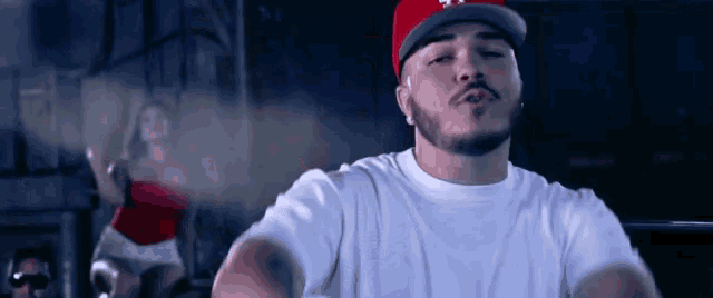 a man with a beard wearing a white shirt and a red hat with ny on it