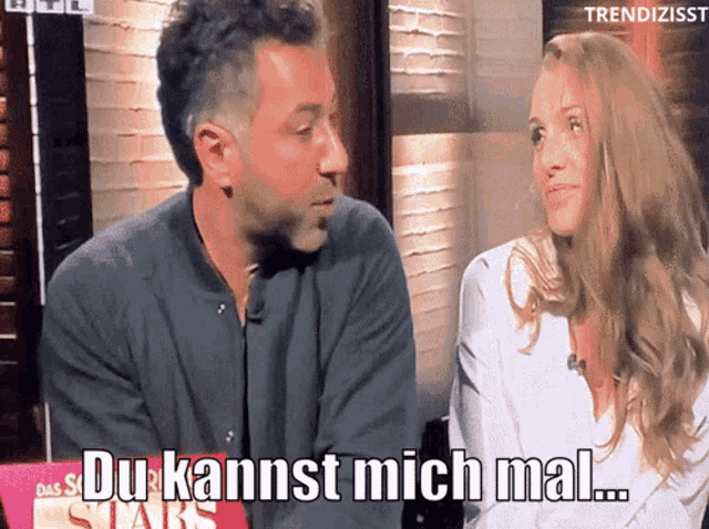 a man and a woman are sitting next to each other and the man is saying du kannst mich mal