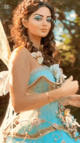 a woman is dressed as a fairy in a blue dress and wings .