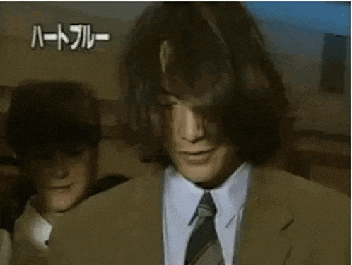 a man in a suit and tie is touching his head .