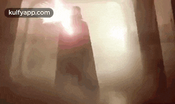 a man in a cape is standing in a dark room with smoke coming out of the ceiling .