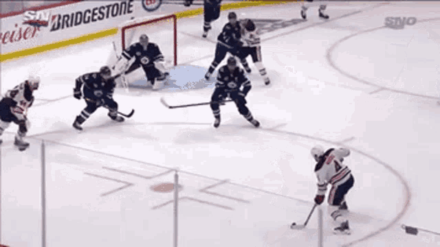 a hockey game is being played in front of a bridgestone ad