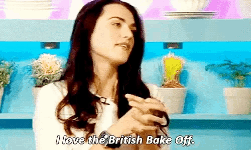 a woman says " i love the british bake off " in front of potted plants