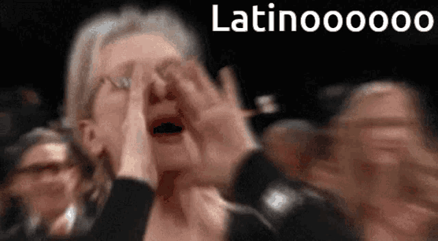a woman is screaming in a crowd with the words latinooooo written on the bottom