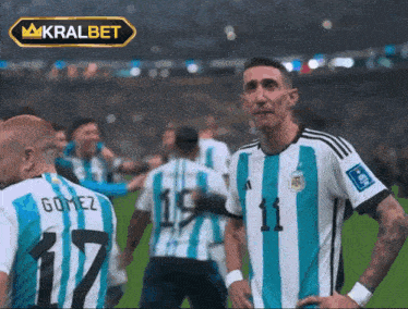 a soccer player with the number 11 on his shirt stands on the field