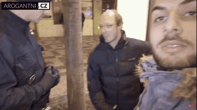 a group of men standing next to each other with a sign that says arrogantnia cz