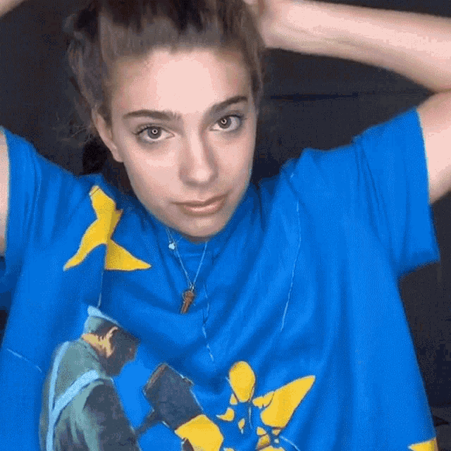 a woman wearing a blue t-shirt with a yellow star on it