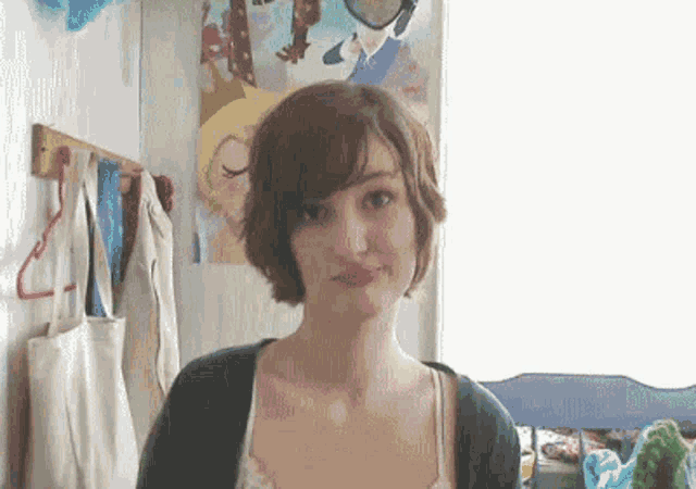 a woman is standing in front of a wall with a picture of a cartoon character on it