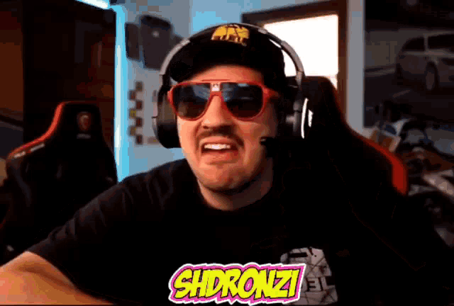 a man wearing headphones and sunglasses has the word shdronzi on the bottom of his shirt