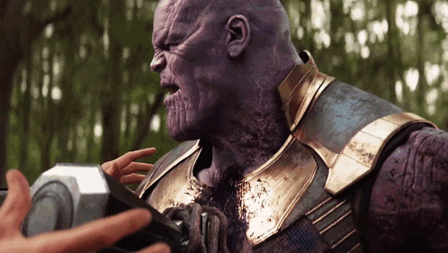 a close up of thanos holding a hammer with a person 's hand