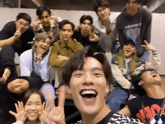 a group of people are posing for a picture together and laughing .