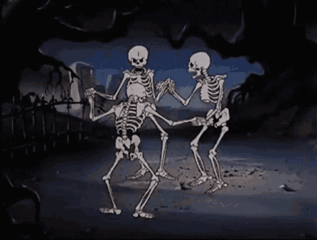 a group of skeletons are dancing together in a cemetery at night .