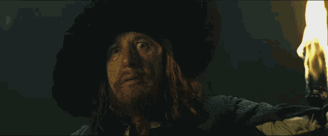 a man with long hair and a beard holds a torch in his hand