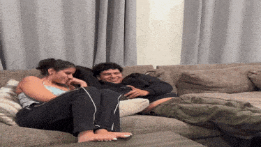 a woman sits on a couch next to a man
