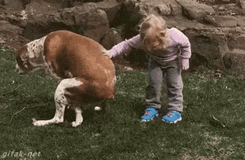 a little girl petting a dog with the words `` good boy '' written on it