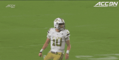 a football player runs on the field with accn written on the bottom