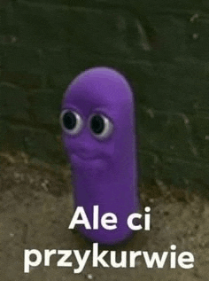 a purple worm with big eyes is standing in front of a brick wall with the words `` ale ci przykurwie '' .