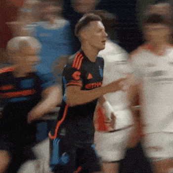 a soccer player wearing a black and orange adidas jersey