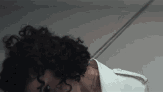 a woman with curly hair is tied up with rope