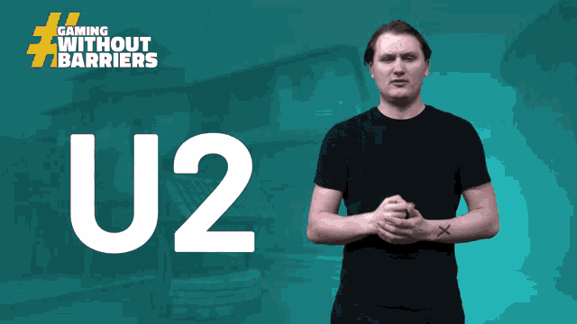 a man in a black shirt stands in front of a u2 logo