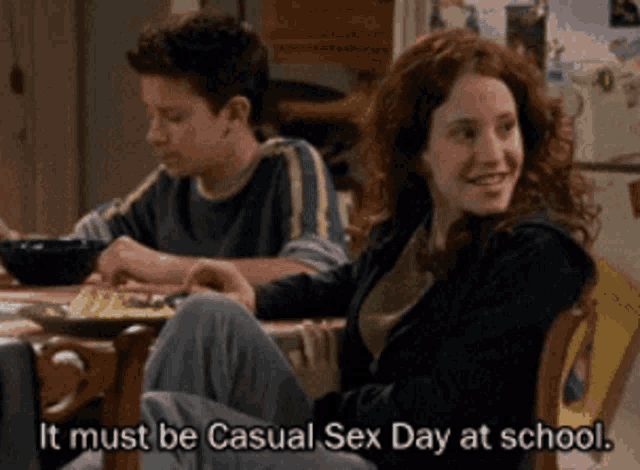 a boy and a girl sit at a table with the words it must be casual sex day at school below them