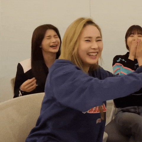 a woman wearing a blue sweatshirt that says ' aa ' on it is laughing