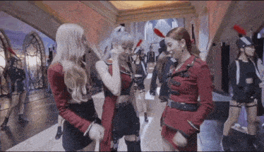 three women are standing next to each other in a hallway .