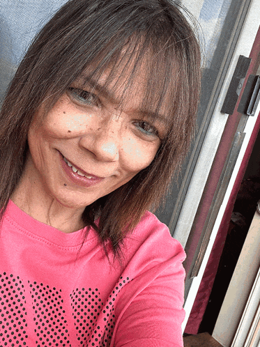 a woman wearing a pink shirt that says ' nike ' on it