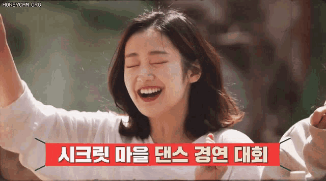 a woman is laughing with a sign that says honeycam.org on it