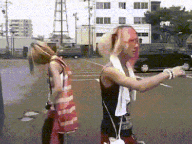 a man with a towel around his neck stands next to a woman with pink hair