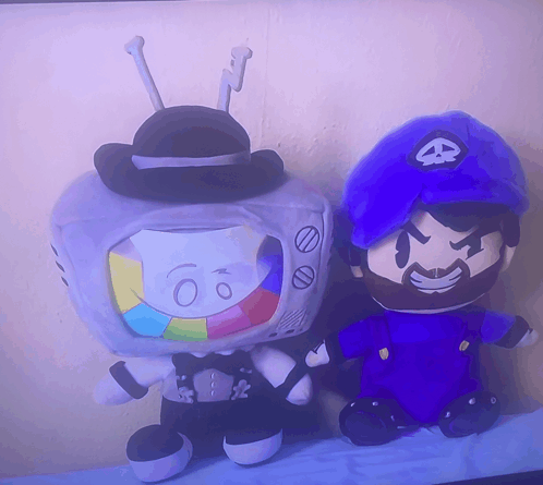 two stuffed toys are sitting next to each other one of which is a tv with the number 60 on it